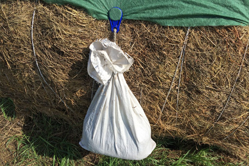 Tightening the straw bale cover with weights